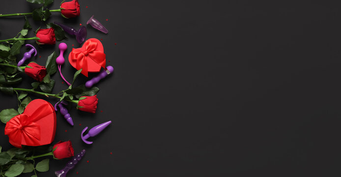 Composition with beautiful rose flowers, gift boxes and different anal plugs from sex shop on black background