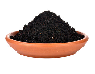 Close-up of dark soil in a terracotta bowl, isolated against a solid black background