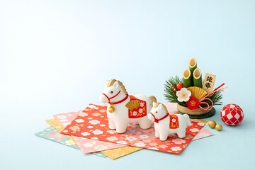 Obraz premium Cute Horse Figures with Japanese New Year Decorations on Light Blue Background