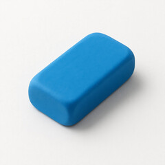 A closeup macro of a blue rubber eraser isolated on a clean white background, resembling a colorful bar of soap or a hygiene object for school and office care