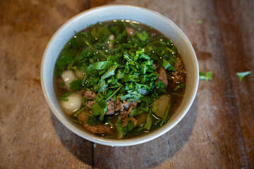 Vietnamese pho bo beef noodle soup with herbs top view