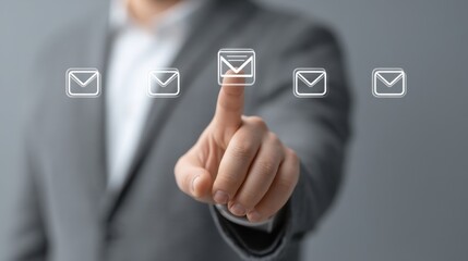 Obraz premium Professional worker in a gray suit touching a digital email icon while interacting with floating messages in a high-tech environment