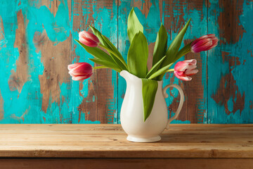 Spring tulip flower bouquet on wooden table over rustic background