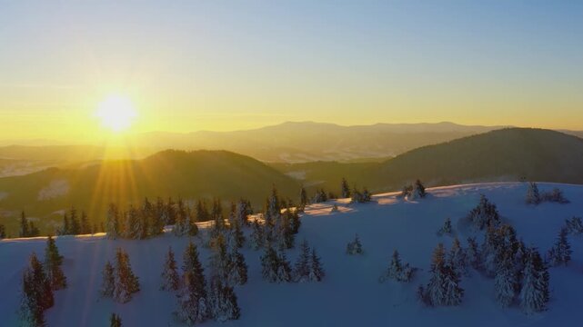 An extraordinary valley with hills and mountains covered with fir forests against the backdrop of a bright fiery sunset
