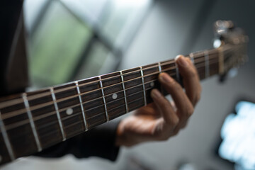 Obraz premium Close-up of hand forming chord on electric guitar fretboard