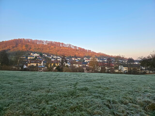 Germany, Rudersberg village houses roofs buildings in valley in winter season at sunset in warm light nature landscape frozen cold temperatures