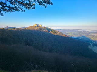 Germany, Hohenneuffen castle ruins on top of mountain at neuffen village surrounded by nature landscape in winter season, fog covering the valley scenery, early morning sunrise