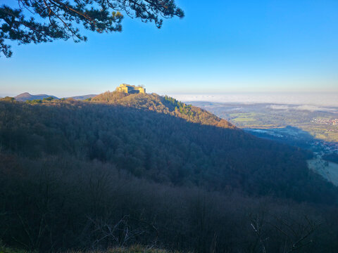 Germany, Hohenneuffen castle ruins on top of mountain at neuffen village surrounded by nature landscape in winter season, fog covering the valley scenery, early morning sunrise