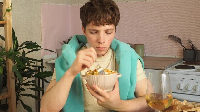An attractive guy eats a salad for lunch.