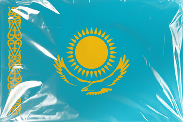 The National Flag of Kazakhstan, Featuring Its Distinctive Blue Background with Golden Sun, Soaring Eagle, and Traditional Ornamental Pattern, Presented Under a Crinkled Transparent Plastic Film
