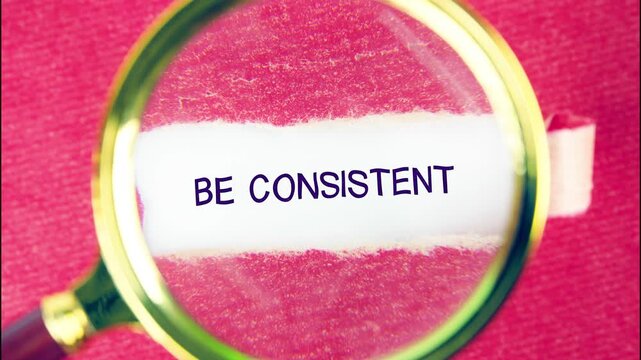 The message Be Consistent is amplified by a magnifying glass, placed on red texture paper. It emphasizes the need for persistent action and constant effort