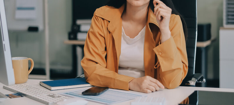 Business woman using calculator for do math finance on wooden desk in office and business working background, tax, accounting, statistics and analytic research concept. - Powered by Adobe