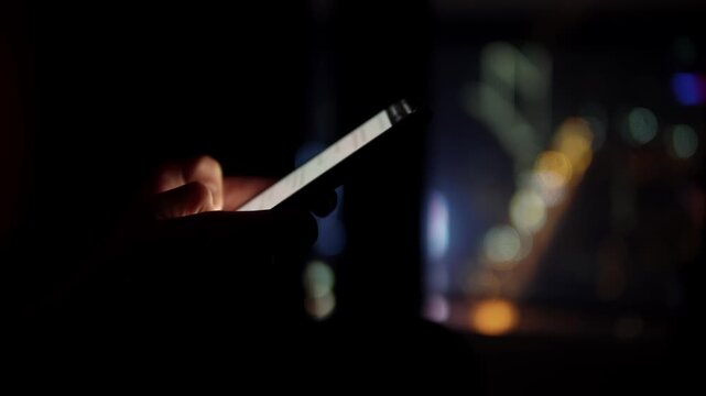 hand holding phone near window with city bokeh, fingertip interacting with glowing screen reflections on glass, soft neon highlights, focused closeup showing interface and notification glow