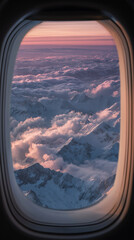 View of clouds and mountains from airplane window at sunset  