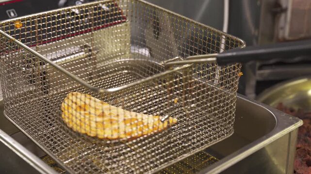 Watch a skilled hand gently lower a chebureki into hot vegetable oil. The crisping process creates a golden exterior while the savory filling cooks to perfection. Enjoy the delightful aroma