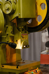 mechanical crank power press with flywheel and ram mechanism for metal stamping and forming operations in industrial manufacturing