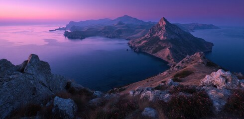 Majestic mountain range meets tranquil ocean at sunrise