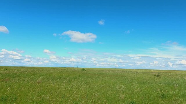 Beautiful aerial footage capturing a bright blue sky with soft clouds, paired with gentle glass pieces or objects blowing across the ground.