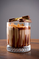 A chocolate cocktail with chocolate decorations stands on a wooden table                               