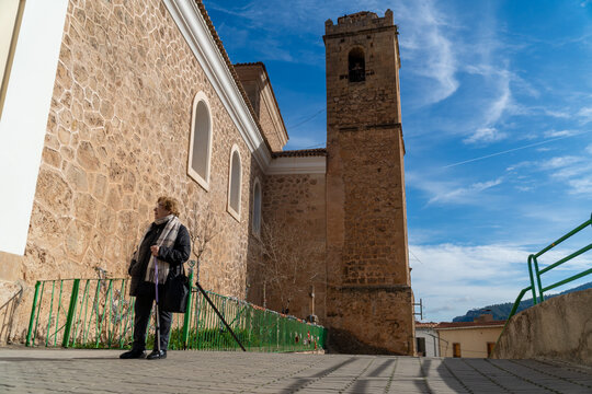 Ayna's church with a woman walking outdoors, in Albacete, Castilla la Mancha (Spain)