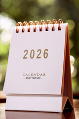 Small white calendar year 2026 on wooden table, with copy space.