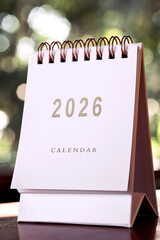 Small white calendar year 2026 on wooden table, with copy space.