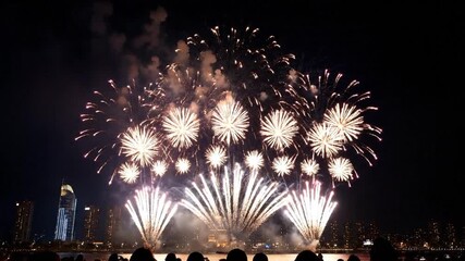 Colorful New Year fireworks explode over the city and river at night, creating bright reflections on the water during a festive holiday celebration display - Powered by Adobe