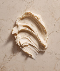 Creamy aesthetic cosmetic swatch smeared on marble background