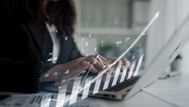 A focused businesswoman works on a laptop, analyzing financial data with a dynamic graph visualization, representing growth and productivity in a sleek office setting. Copula - Powered by Adobe