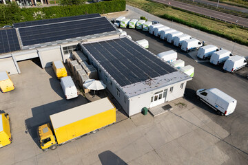Delivery vans and trucks hub with solar panels on a roof. Fleet of vehicles