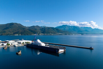 Aerial view of a luxury yacht refit, repair, service and maintenance in a floating dock at a marina.