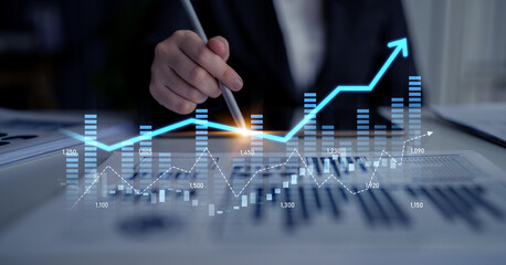 A business analyst engages with financial documents while highlighting a growth chart with a digital pen, representing data analysis and market trends in a modern office environment. Scalp