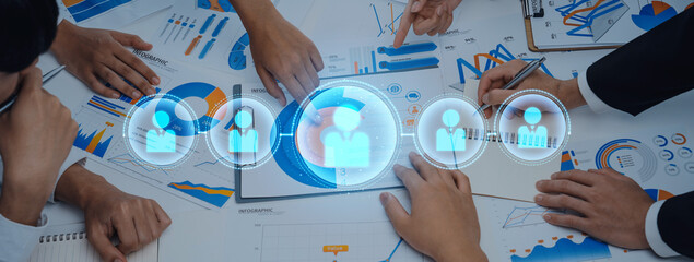 Group of professionals collaborating in a modern office setting, analyzing charts and data during a business meeting, emphasizing teamwork and communication. Trope