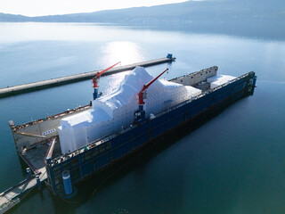 Aerial view of a luxury yacht refit, repair, service and maintenance in a floating dock at a marina.