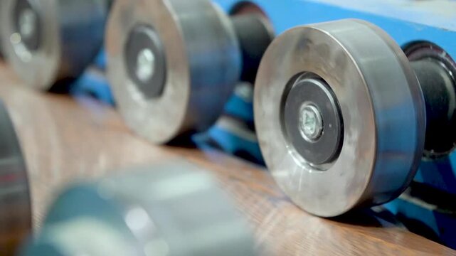 A rolling machine in the factory produces and presses metal sheets with high precision for roofing sheet manufacturing. roofing production processes. Roof sheet factory. Steel roofing forming machine.