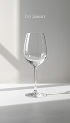 Empty wine glass on a white surface with text "Dry January" promoting sobriety and healthy lifestyle choices
