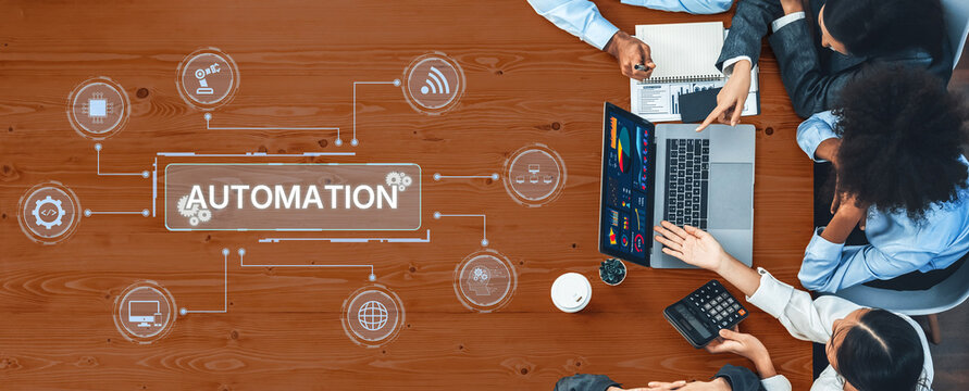 A diverse business team collaborates over a laptop in an engaging workspace, focusing on automation concepts and innovative approaches to enhance productivity. Trope - Powered by Adobe