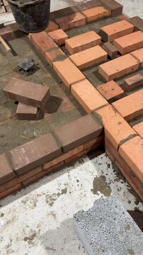Fresh brickwork of a heating stove ash pit and bench. Smoke channels of the bench are visible. Vertical video.