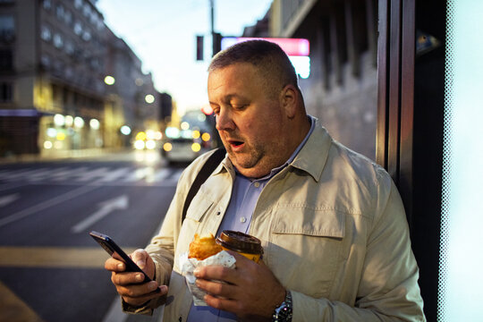 Adult man shocked by phone at city bus stop