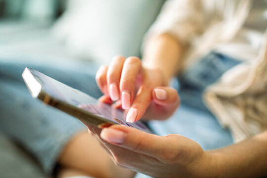 Young adult using smartphone at home, relaxed - Powered by Adobe