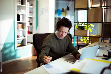 Adult man focused on notes in modern office