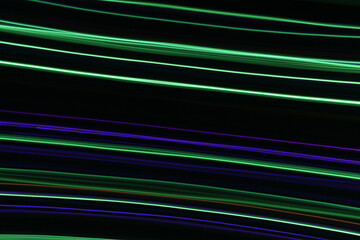 A long exposure photograph. Light painting photography, vibrant fairy lights in parallel lines and streaks against a black background