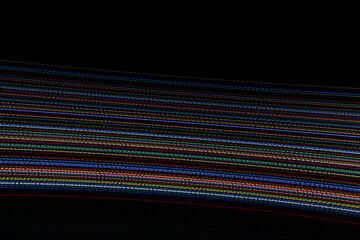 A long exposure photograph. Light painting photography, vibrant fairy lights in parallel lines and streaks against a black background