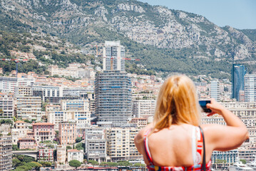 Femme touriste photographiant Monaco. Panorama mon&eacute;gasque. Ville de la C&ocirc;te d'Azur. Blonde en &eacute;t&eacute; dans le sud m&eacute;diterran&eacute;en. 
