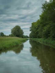 Fototapeta premium Narrow waterway bordered by dense tall green foliage and reeds mirrors dramatic stormy sky during serene daytime on river