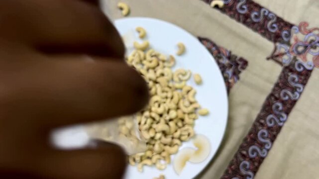 Hand sorting grains on plate, close up