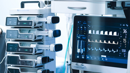 Medical equipment in a modern operating room, featuring advanced monitors and infusion pumps, illustrating high-tech surgical environment with copy space