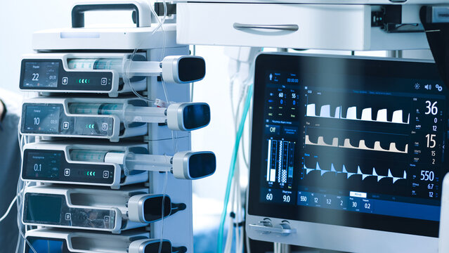 Advanced medical equipment in a modern operating room, featuring monitors and infusion pumps, showcasing high-tech healthcare technology and surgical precision