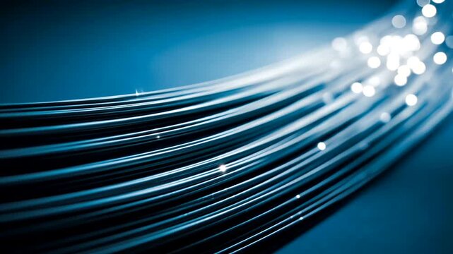Flowing bright light illuminates polished, curved fiber optic cables on a blue field