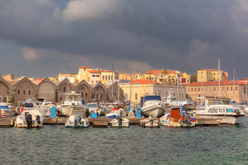 Docked sailing yachts in the Venetian Harbor in Chania, Crete, Greece with cloudy sky